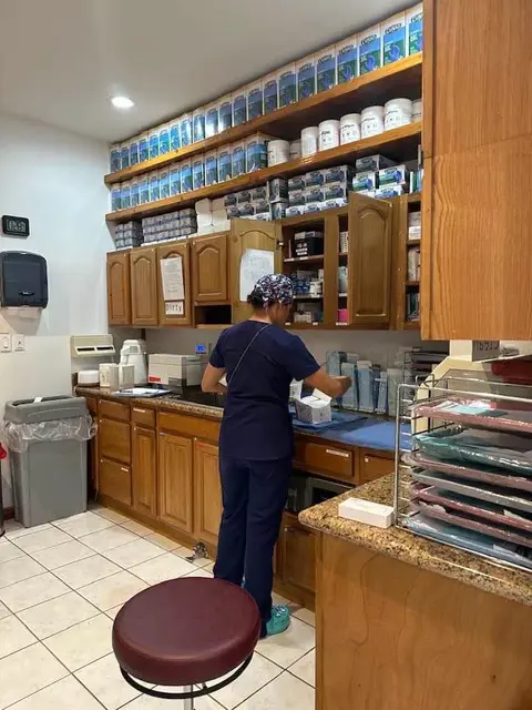 Staff member in scrubs preparing supplies in the clinic dispensary