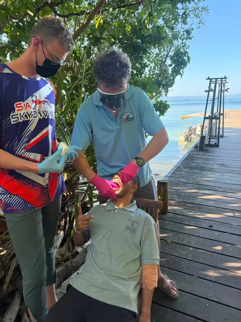 Two volunteers treating a patient on a seaside boardwalk
